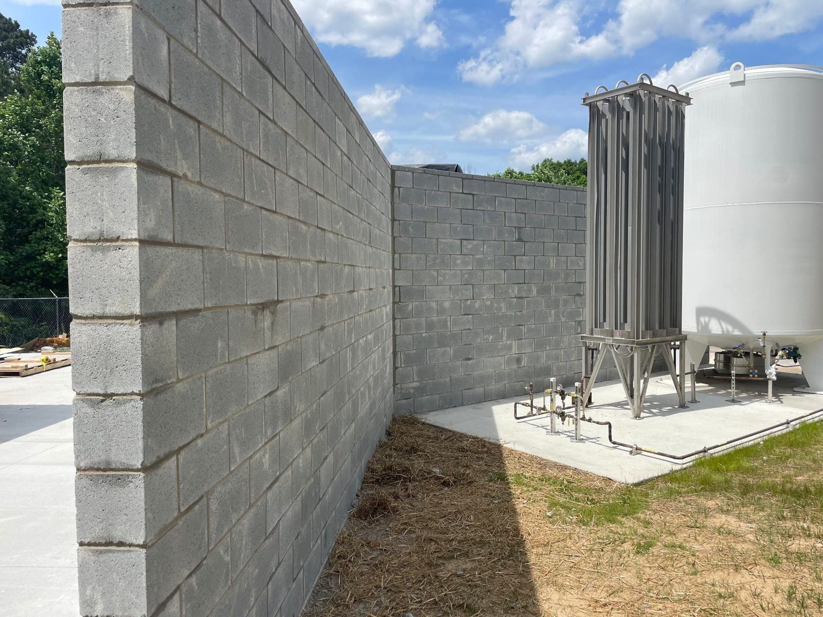 Tall concrete block wall around equipment on a concrete slab at a commercial site in Gwinnett County, GA