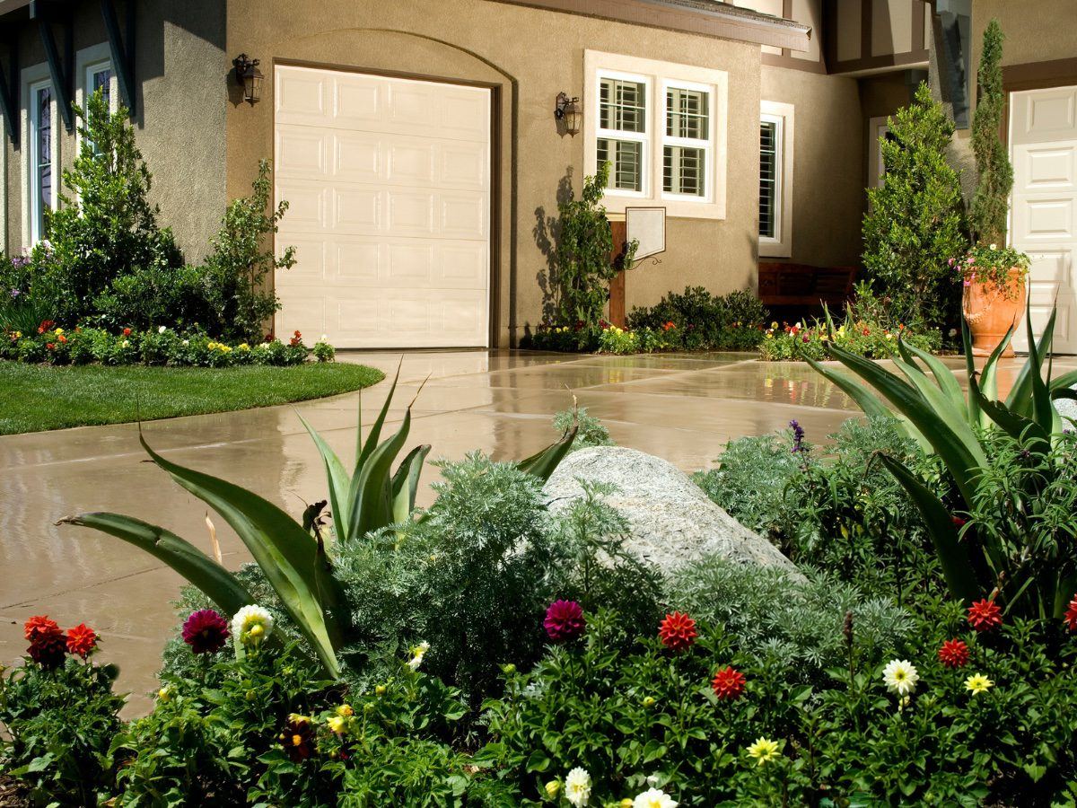 Fresh concrete driveway in front of a garage with garden beds in Gwinnett County, GA